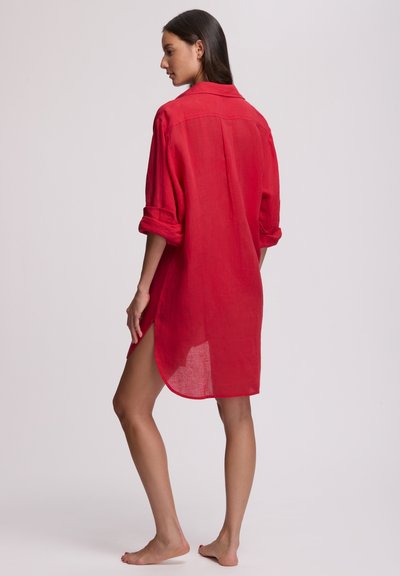 Κόκκινο λινό φόρεμα-πουκάμισο με μανίκια γυρισμένα, γιακά με κουμπιά, πλαϊνές σχισμές και ελαφρώς μακρύτερο πίσω τελείωμα. Ελαφρύ, υφασμάτινο με υφή.