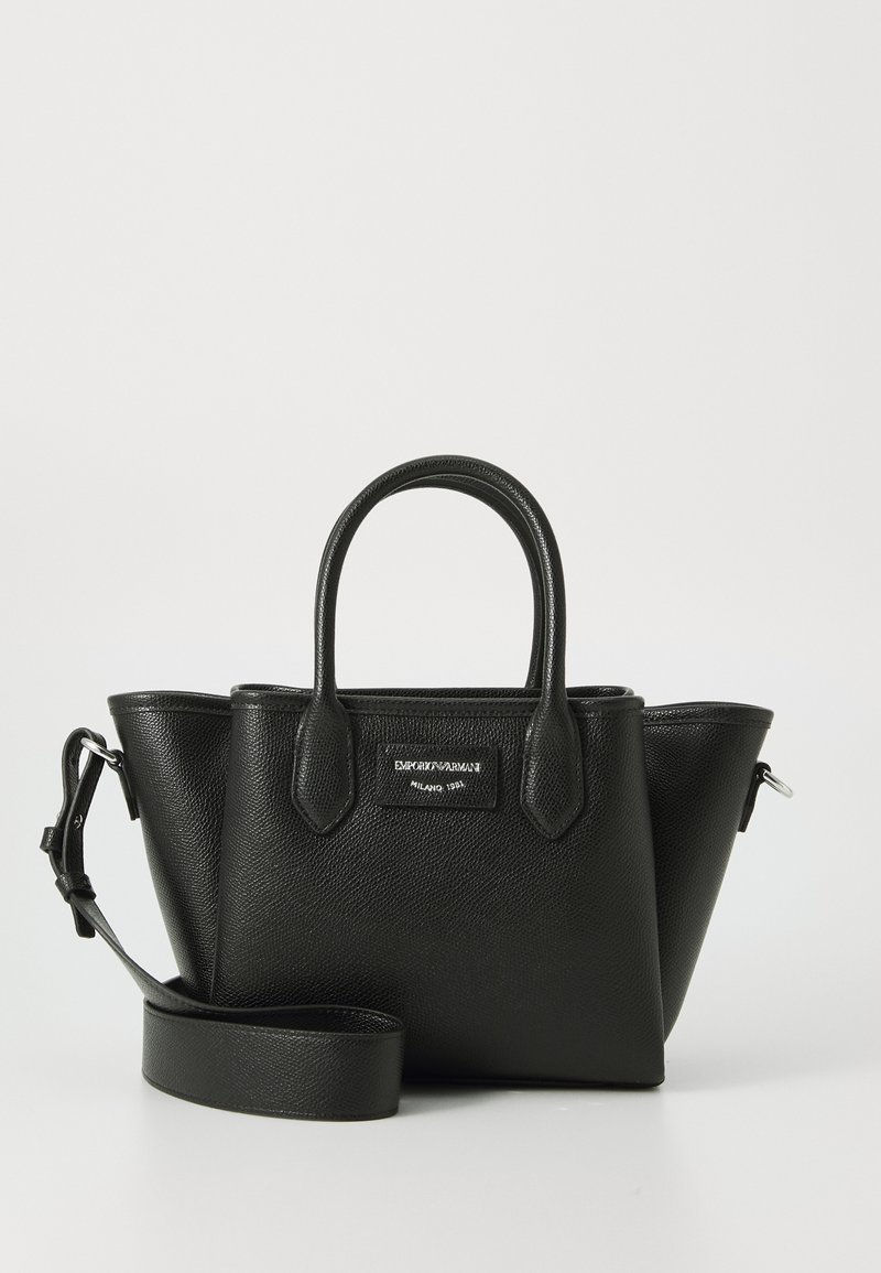 Melna struktūrēta rokassoma, izgatavota no teksturētas ādas. Aprīkota ar divām īsām rokturiem, regulējamu plecu siksnu un logotipa plāksni priekšpusē.