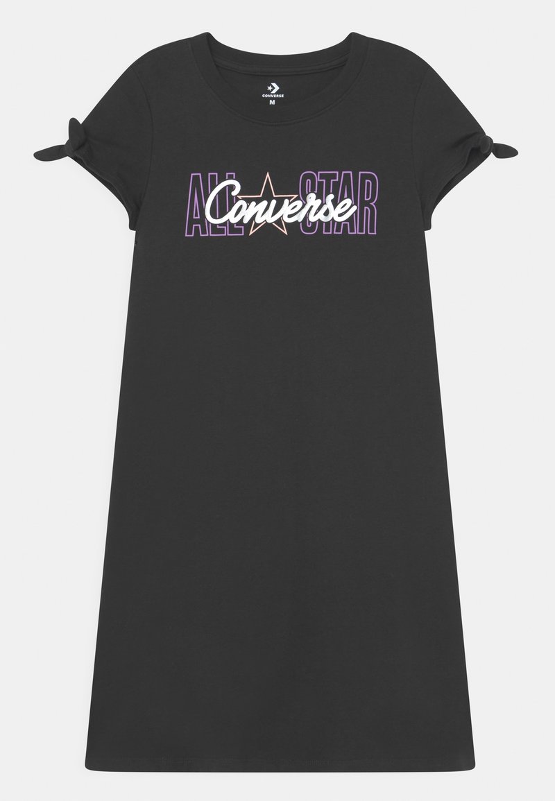 Czarna bawełniana sukienka typu t-shirt z krótkimi rękawami, z węzłowymi detalami oraz grafiką "ALL STAR Converse" w purpurowym i białym napisie.