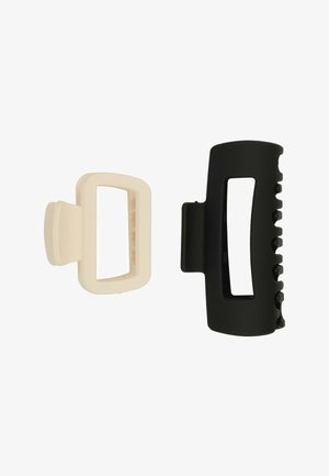 Due mollette per capelli rettangolari affiancate, una beige e una nera, con centri aperti e denti per afferrare i capelli.