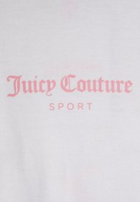 Baltos medvilnės audinys su tekstu "Juicy Couture" stilizuotu rožiniu šriftu, o žemiau paprastesniu rožiniu šriftu užrašas "SPORT".
