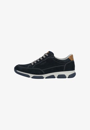 Zapatilla deportiva casual negra de hombre con cordones grises, suela blanca, detalles en gris oscuro y lengüeta trasera color beige, vista lateral sobre fondo blanco.