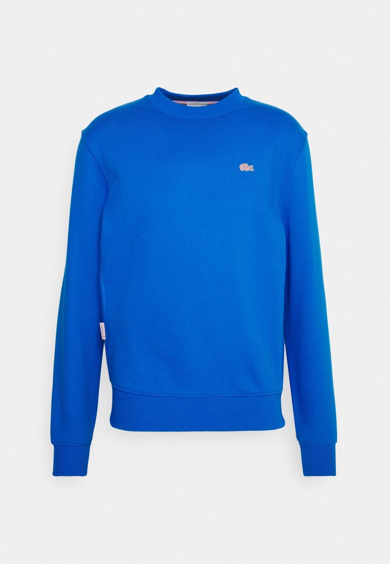 Sweat-shirt bleu vif à manches longues avec col ras du cou, poignets et ourlet côtelés, présentant un petit logo de marque brodé sur la poitrine gauche.