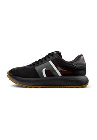 Black athletic shoe with a mesh upper, white accents, thick black sole, and textured gum rubber outsole. Features lace-up design.