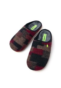 Pantofole in feltro con un motivo geometrico multicolore in rosso scuro, marrone e nero, dotate di un interno morbido e di un piccolo logo verde.