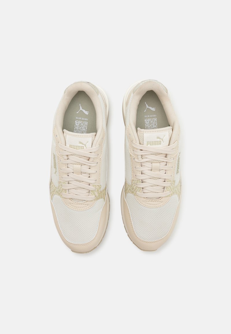 Sneakers z jasnobeżową siatkową cholewką, teksturowanymi akcentami, z zamknięciem na sznurówki i gumową podeszwą. Posiadają logo na języku i boku.