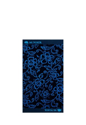 Asciugamano blu intenso con un motivo floreale ripetuto in blu brillante. Logo del marchio "SUNDEK" visibile sui bordi superiore e inferiore.