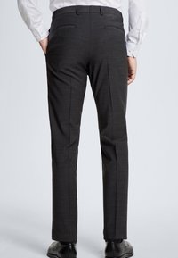 Mörkgrå skräddarsydda byxor med en texturerad yta, som har två bakfickor och rak benform, bar med svarta finskor.