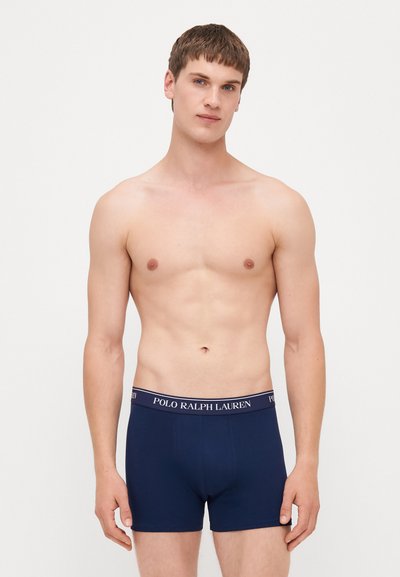 Modre bokserice iz raztegljivega bombaža, ki imajo mehak elastičen pas z logotipom "POLO RALPH LAUREN". Gladak, prilegajoč se dizajn.