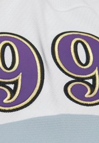 Tessuto bianco con numeri "99" in bold viola bordati da ricami dorati e accenti neri, il tutto su una superficie liscia.