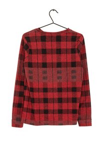 Chemise à manches longues en tissu à carreaux rouges et noirs, avec un col rond et une coupe droite, dotée de coutures visibles sur les manches.