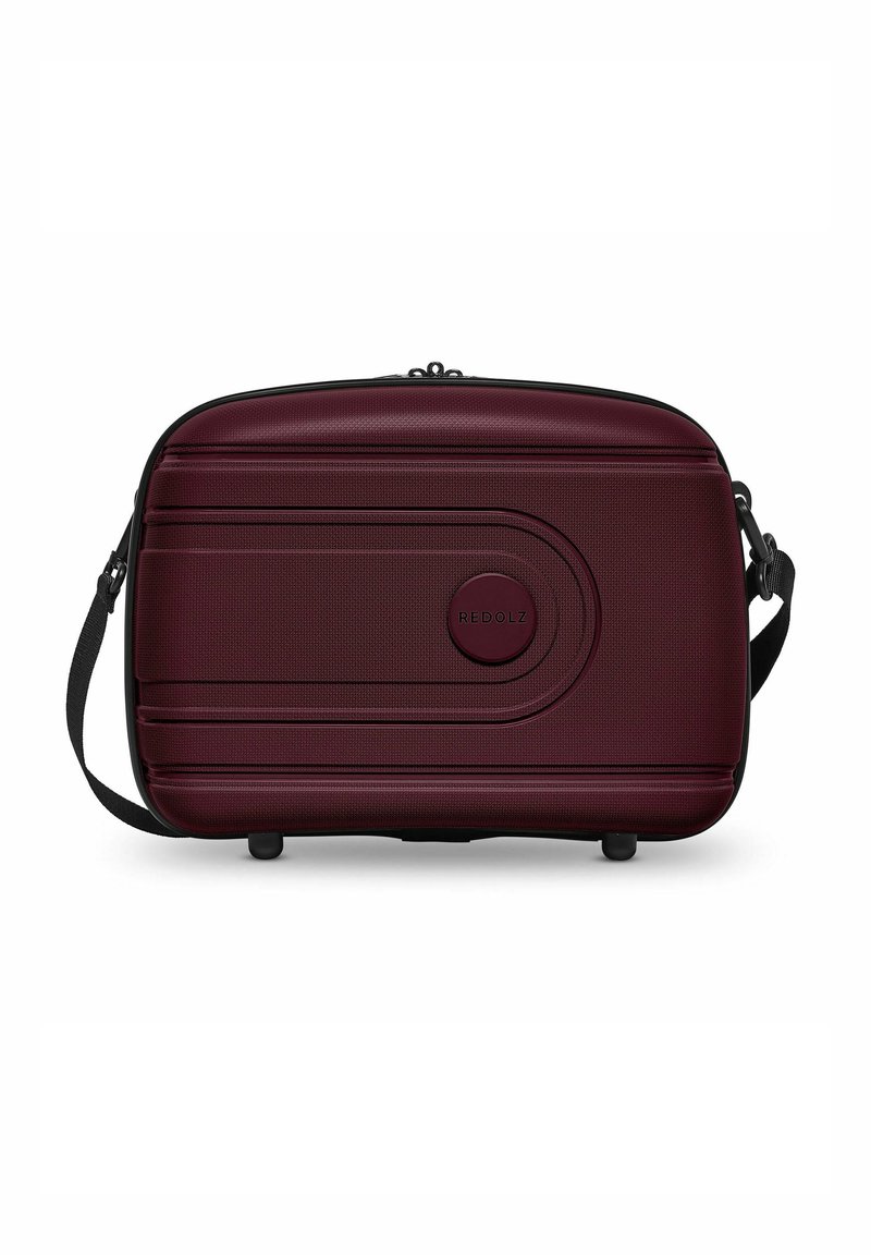 Rode koffer, diep bordeauxrood, gestructureerd oppervlak, ronde vorm, ritssluiting, verstelbare schouderband, gemarkeerde ronde accent aan de voorkant.