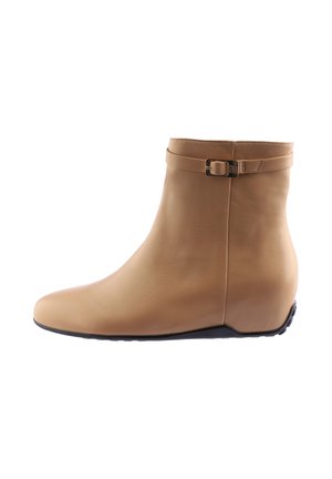 Beige leather ankle boots with a rounded toe, low wedge heel, and a buckled strap around the cuff. Smooth texture and minimalistic design.