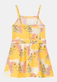 Keltainen mekko, jossa on spagettiolkaimet, esittelee leikkisää kuviota unicornien ja nuudelikulhojen kanssa kermanvärisellä taustalla, jossa on vaaleanpunaisia pilvivivahteita.