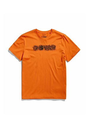 Jasně oranžové tričko s krátkým rukávem s černým opotřebovaným nápisem "RAW STAR" na hrudi, ležící na bílém pozadí.