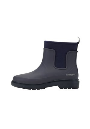Bota de lluvia hasta el tobillo en goma gris oscuro con un upper textil en azul marino, suela texturizada y una pequeña lengüeta para facilitar su uso.