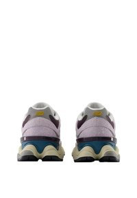 Zapatillas deportivas en tonos púrpura y gris con tela texturizada, detalles de malla y una entresuela color aguamarina. Diseño de suela redondeada y en capas con detalles en el talón.