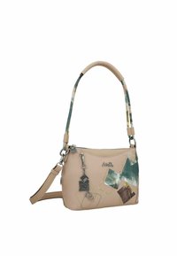 Bolso de mano de cuero beige con una correa de hombro desmontable, que presenta un diseño abstracto colorido, herrajes plateados y un charm decorativo.