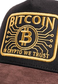 Schwarze Kappe mit braunem Wildleder-Visier. Verziert mit goldener Stickerei mit der Aufschrift "BITCOIN" und "IN CRYPTO WE TRUST", umgeben von schaltkreisähnlichen Details rund um ein Bitcoin-Symbol.
