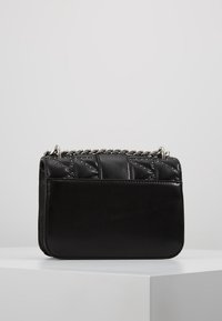 Borsa a tracolla nera in pelle con design trapuntato, tracolla in catena argentata e dettagli borchiati sulla parte anteriore. Texture liscia e forma rettangolare.