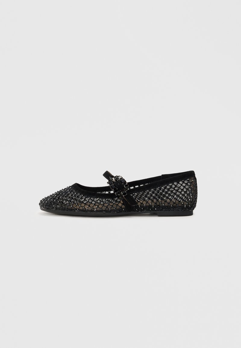Ballerines noires avec empilage en mesh et une boucle décorative. Bout rond, tige légèrement texturée, semelle plate avec un minimum de détails.