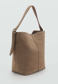 Borsa a spalla in suede marrone con un'ampia apertura, lati rigonfi e tracolla regolabile. Presenta una texture liscia e un design minimalista.