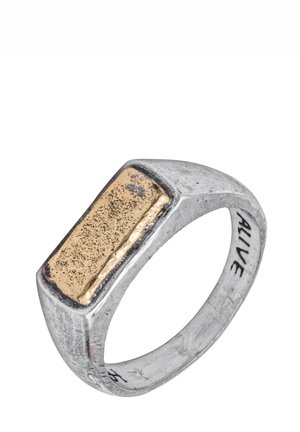 Bague en argent avec un dessus rectangulaire texturé couleur or et le mot "ALIVE" gravé sur la bande intérieure.