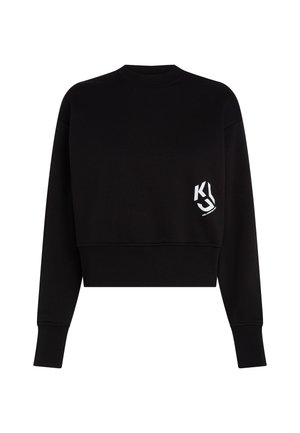 Sort cropped sweatshirt lavet af blødt stof, med rund halsudskæring og lange ærmer. Viser et hvidt logo på venstre brystområde.