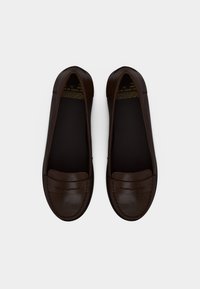 Ζευγάρι σκούρα καφέ δερμάτινα loafers με λεπτομέρειες ραφής και κλασικό σχέδιο με λουράκι στο κέντρο, από πάνω σε λευκό φόντο.