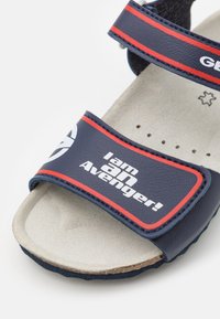 Sandal navy blu con due cinturini regolabili, con una grafica che recita "Io sono un Vendicatore!" in bianco sul cinturino anteriore. Soletta testurizzata.