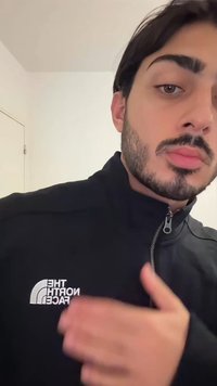 Casaco preto com fecho éclair, com o logótipo "The North Face" em branco na zona do peito esquerdo. O tecido parece liso, com um design de gola padrão.