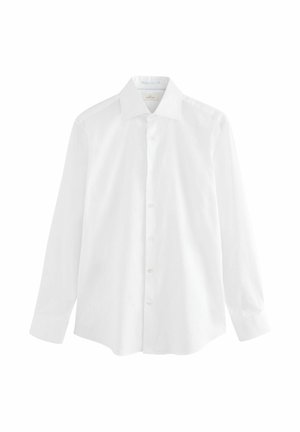 Vit långärmad skjorta i ett mjukt bomullstyg. Har en klassisk krage, knappstängning fram och en avslappnad passform med rak nederkant.