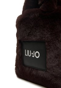 Borsa a tracolla in pelliccia sintetica marrone con una toppa in pelle nera che presenta il logo bianco "LIU•JO". Texture morbida, forma quadrata e senza componenti metalliche visibili.