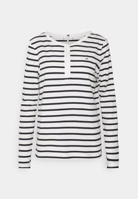 Long-sleeve striped shirt in white and navy, featuring a rounded neckline, button placket, and small logo accent on the chest.