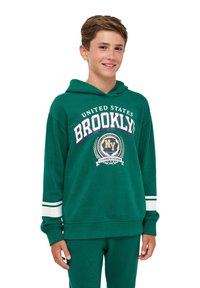 Felpa verde con grafica frontale che presenta "BROOKLYN" e "CHAMPIONSHIP". Accentuata da strisce bianche sulle maniche; realizzata in tessuto testurizzato.