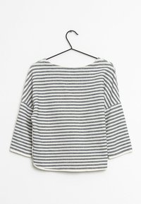 W paskowany pulower z szerokim dekoltem, charakteryzujący się naprzemiennymi granatowymi i białymi poziomymi paskami, rękawami o długości trzy czwarte oraz miękką teksturą.