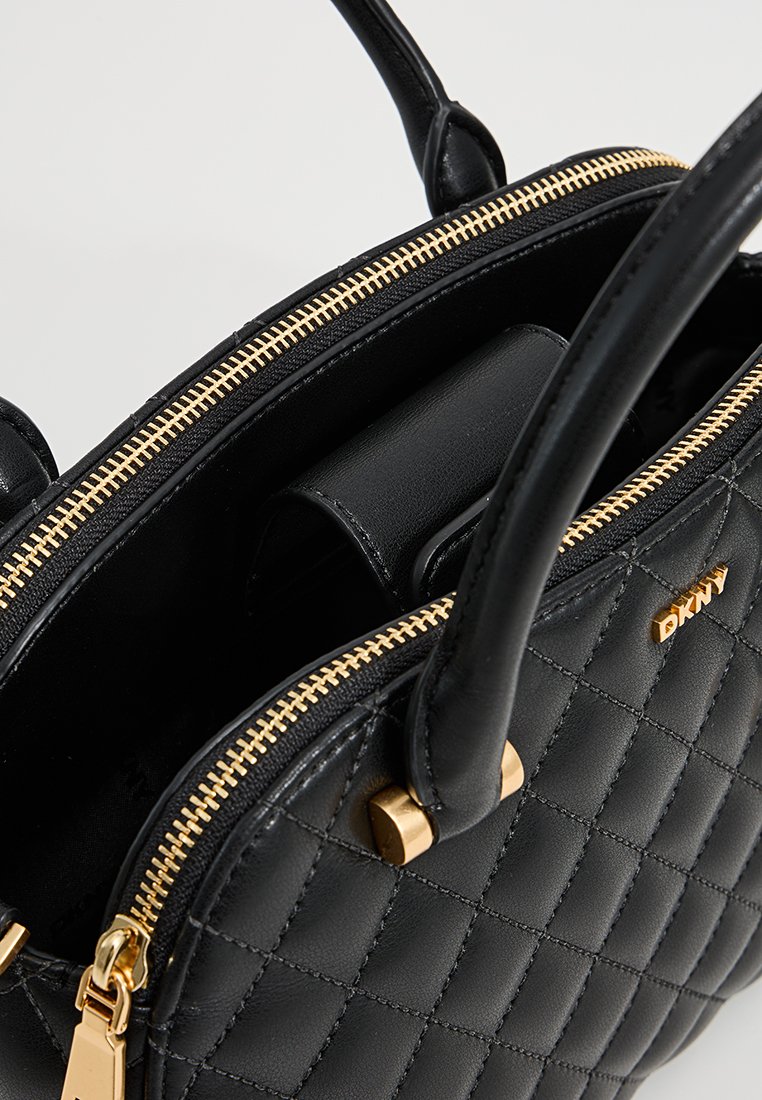 Schwarze gesteppte Lederhandtasche mit goldenem Reißverschluss und Beschlägen. Verfügt über zwei Griffe und ein Innenfach zur Organisation.