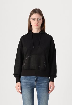 Sudadera negra con un bolsillo frontal, capucha con cordón y dobladillo acanalado. Presenta una textura suave y lisa con un sutil detalle de costura.