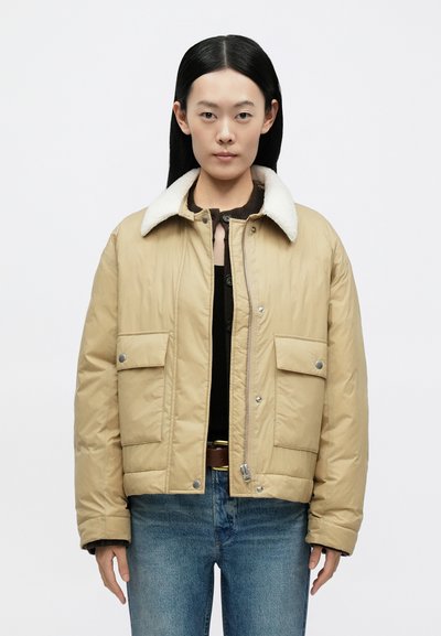 Beežist turriline jope valge kunstkarusnahast kraega, eest tõmblukuga ja kahe esiklapiga taskuga. Kangas tundub pehme ja kergelt läikiv.