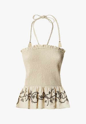 Haut à bretelles smocké beige avec des bretelles nouées tressées et une broderie florale noire le long de l'ourlet à volants.