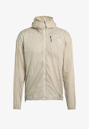 Beige lightweight jacket with a hood, featuring a zippered pocket, textured pattern, and elastic cuffs for a secure fit.