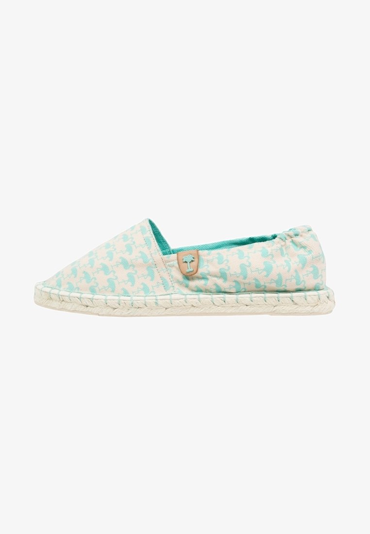 Chaussure décontractée à enfiler en tissu beige clair, motif chiens vert menthe, semelle en jute tressée, et petite étiquette en cuir avec logo palmier sur le côté.