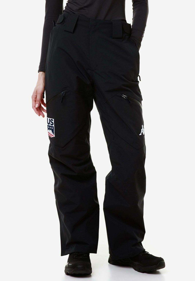Pantaloni da neve neri con una vestibilità ampia, tasche con cerniera su entrambi i lati e un'etichetta con "USA" e stelle. Realizzati in materiale resistente e impermeabile.