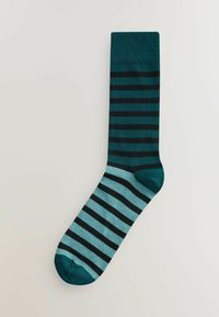 Enkelt sok med vandrette striber i turkis og sort, med en ensfarvet turkis tå og manchet på en lys baggrund.