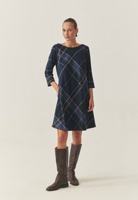 Marineblaues Kleid mit einem diagonalen Karomuster in Grün, Lila und Weiß. Verfügt über Dreiviertelärmel und eine lässige A-Linienform.