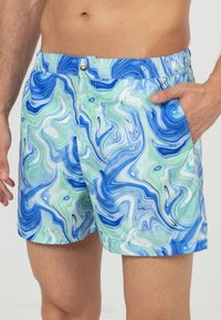 Blauwe en groene gemarmerde zwembroek met een elastische tailleband en zijzakken. Lichtgewicht stof met een gladde textuur en glanzende afwerking.