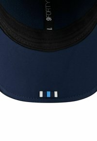 Marineblaues Cap mit einem schwarzen Netzinnenteil, gekennzeichnet durch einen gebogenen Schirm und einem mehrfarbigen Akzentstreifen an der Vorderseite in Blau und Weiß.