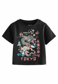 Mustassa puuvillateepaidassa on värikkään lohikäärmeen grafiikka, kukkaelementtejä ja sana "TOKYO" vaaleanpunaisena alareunassa. Lyhyet hihat, pyöreä kaula-aukko.