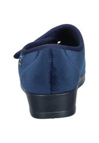 Navy blue slipper with a soft suede texture, rounded shape, elasticated top edge, and a black rubber sole. Features a small logo detail.