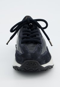 Baskets de sport navy en daim et cuir, avec une semelle rembourrée, un bout rond et des lacets noirs. Motif de traction visible sur la semelle extérieure.